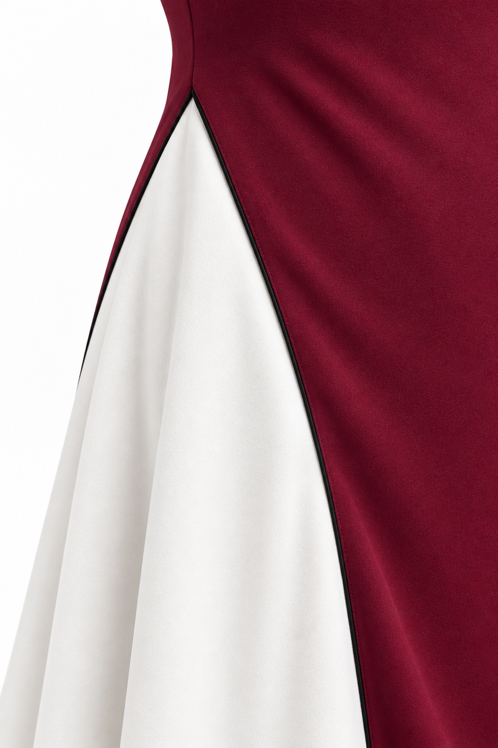Detalle de la unión del panel blanco, el vivo negro y el tejido burdeos del vestido Camilla